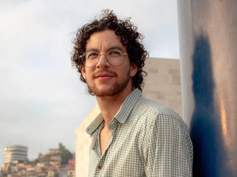 A man smiling in his glasses outside