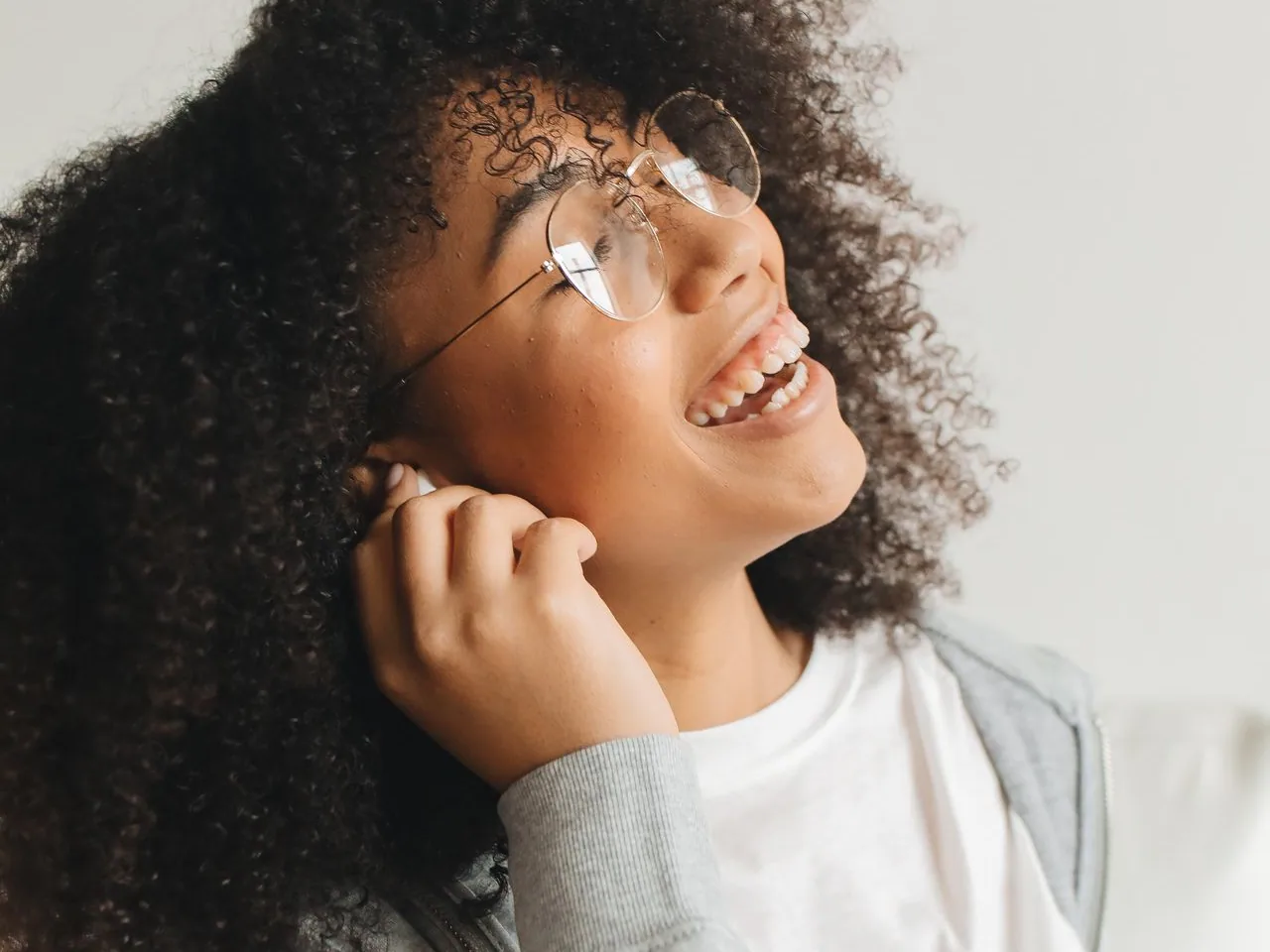 A woman smiling in her glasses